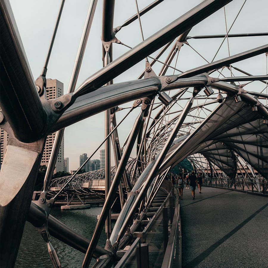 unique steel bridge with people walking in the background